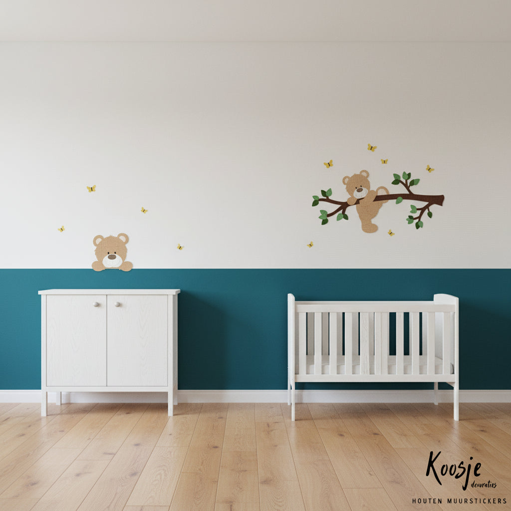Ideeën wanddecoratie babykamer donkerbruine tak met groene bladeren en een klauterend beige beertje boven een blauwe lambrisering