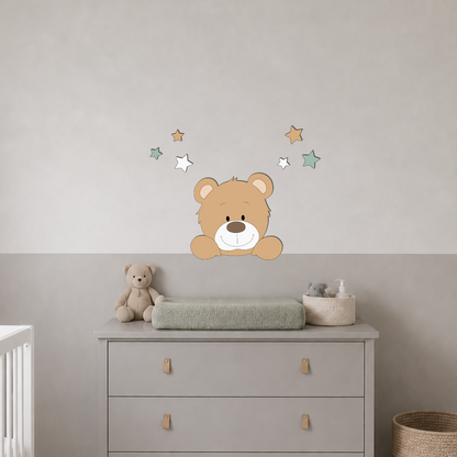 Babykamer met wit ledikant, grijze commode en muurdecoratie van een beertje met sterren in groen, wit en beige.
