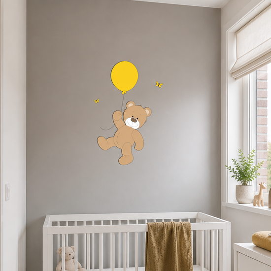 Babykamer met wit ledikant en commode, gedecoreerd met houten wanddecoratie van een beertje dat aan een ballon zweeft.