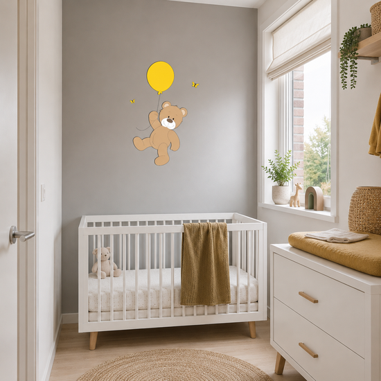 Babykamer met wit ledikant en commode, gedecoreerd met houten wanddecoratie van een beertje dat aan een gele ballon zweeft.
