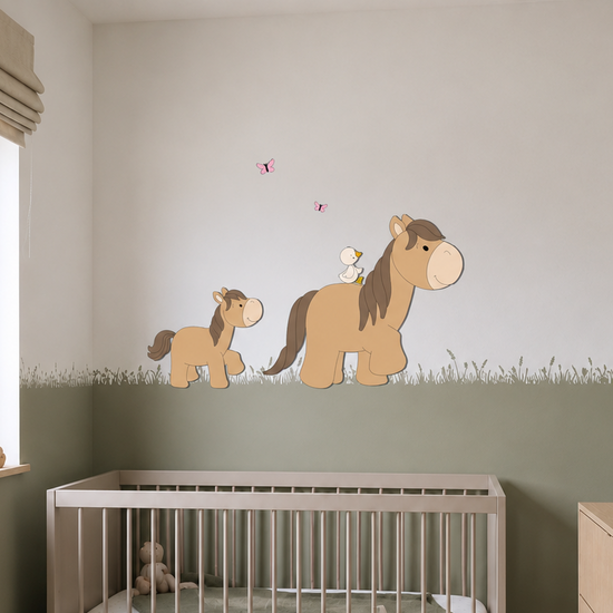 Babykamer met wit ledikant, houten commode, groene lambrisering en  boerderijthema wanddecoratie van een paard met veulen, vogeltje en vlinders.