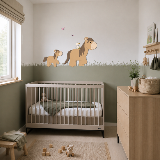 Babykamer met wit ledikant, houten commode, groene lambrisering en  boerderijthema wanddecoratie van een paard met veulen, vogeltje en vlinders.
