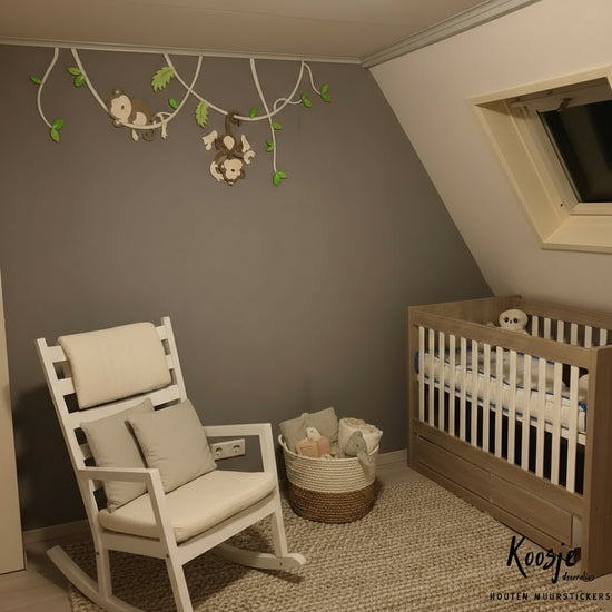 Houten muurdecoratie voor kinderkamer, twee aapjes hangend aan lianen met groene bladeren, donkere muur