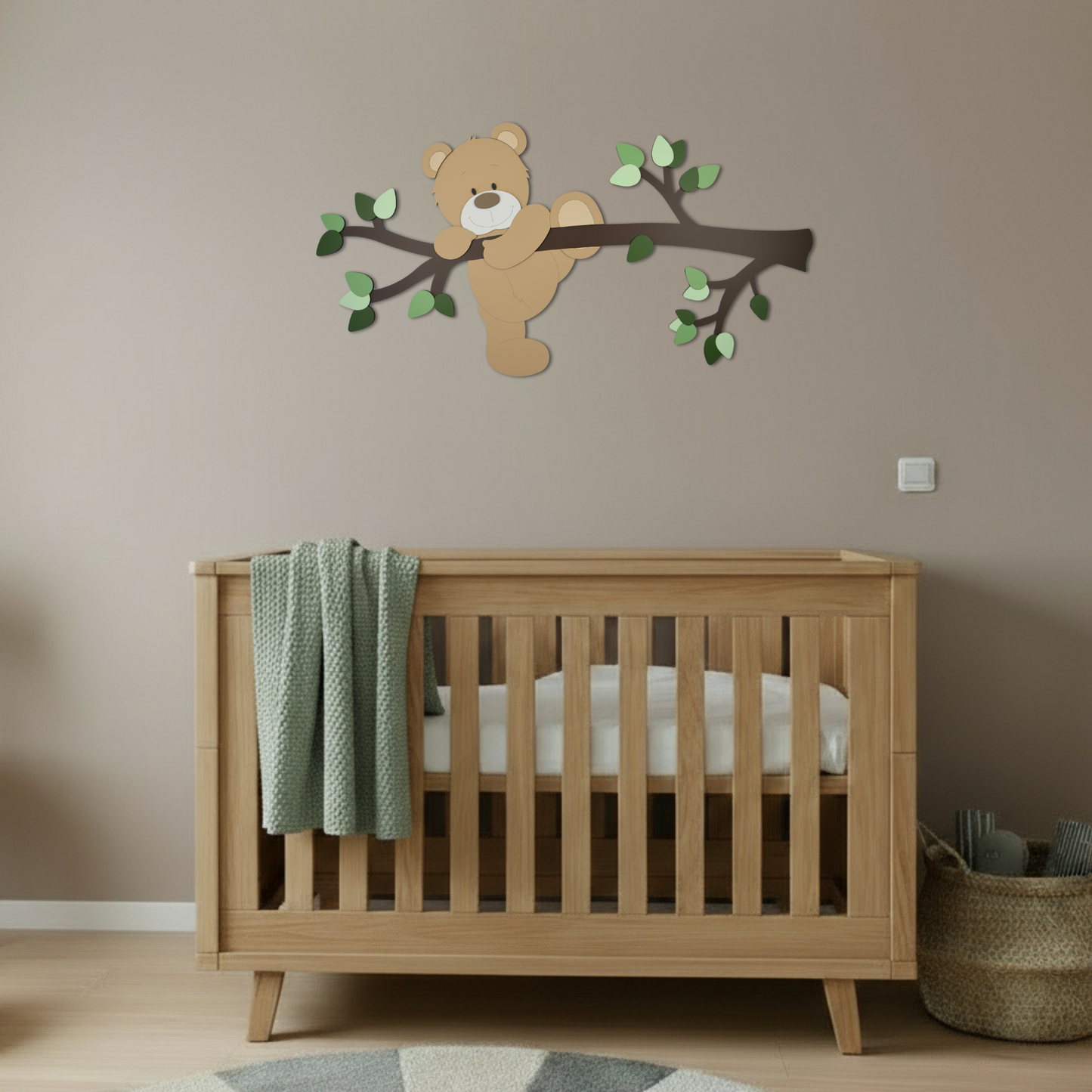 Houten decoratie babykamer met tak, groene bladeren en klauterend beige beertje