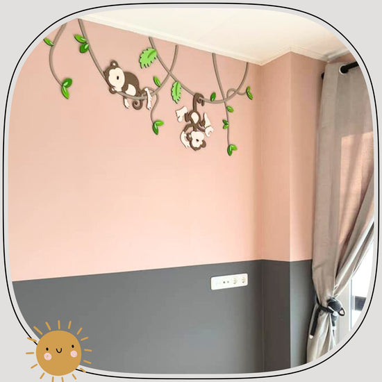 Houten muursticker voor babykamer, twee aapjes hangend aan lianen met groene bladeren, roze muur