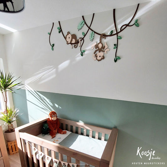 Houten muursticker voor babykamer, twee aapjes hangend aan lianen met groene bladeren, boven groene lambrisering