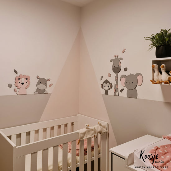 Houten muurstickers met safaridieren voor de babykamer – giraf, leeuw en olifant als natuurlijke wanddecoratie in grijs met roze tinten.