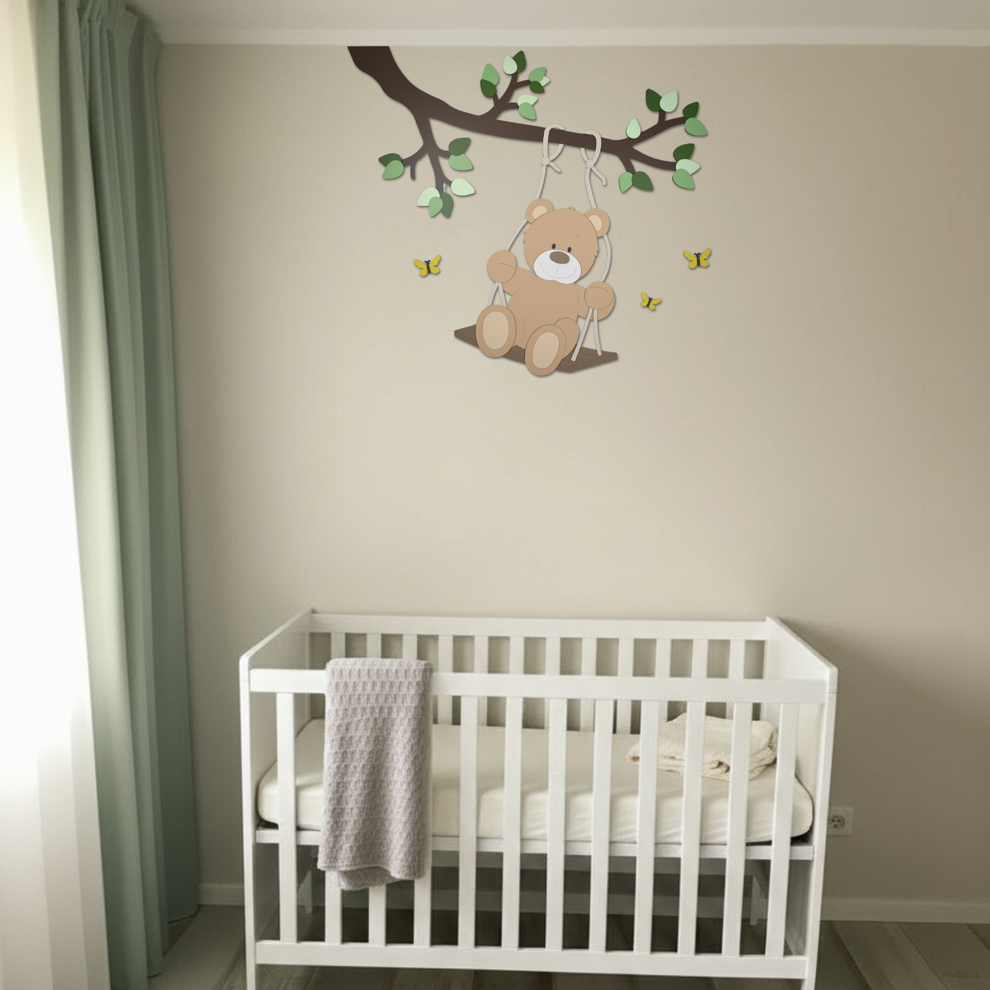 Houten decoratie babykamer met tak, groene bladeren en schommelend beige beertje