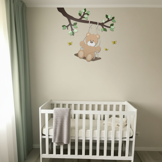 Houten decoratie babykamer met tak, groene bladeren en schommelend beige beertje