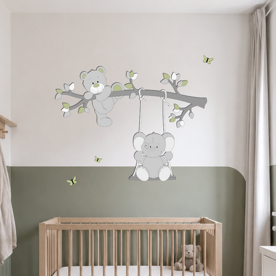 Houten muurdecoratie voor de babykamer met een beertje op een tak en een schommelend olifantje. De decoratie is uitgevoerd in zachte grijstinten met roze accenten, blaadjes en vlinders en past mooi in een bos-, dieren- of natuurthema.
