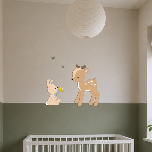 Babykamer met wit ledikant, groene lambrisering en houten wanddecoratie van een hertje en konijntje met vlinders.