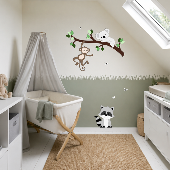 Babykamer met witte plankenvloer en wiegje. Muurdecoratie van tak met aapje en koala en wasbeertje op de plint.
