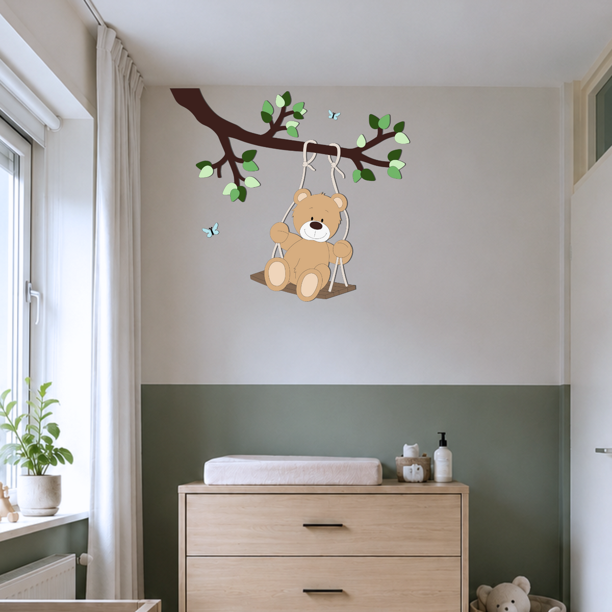 Moderne babykamer met groene lambrisering en houten meubels en muurdecoratie van schommelend beertje aan een tak.