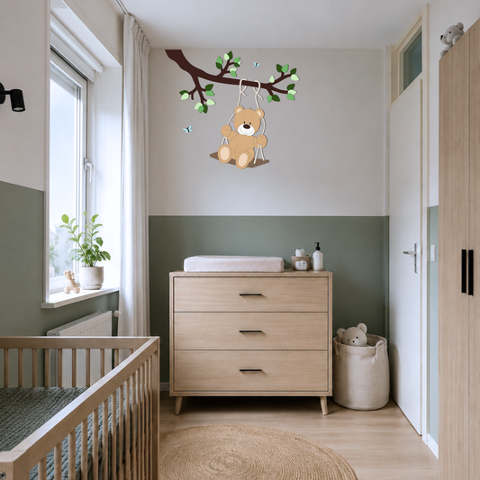 Moderne babykamer met groene lambrisering en houten meubels en muurdecoratie van schommelend beertje aan een tak.
