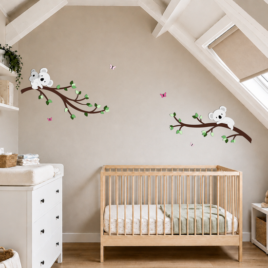 Lichte natuurlijke kinderkamer  met muurdecoratie van 2 takken in groentinten, met koala's.