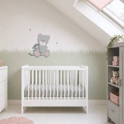 Licht ingerichte babykamer met houten muurdecoratie van een grijze beer met knuffel, sagegroene muur en oudroze accessoires.