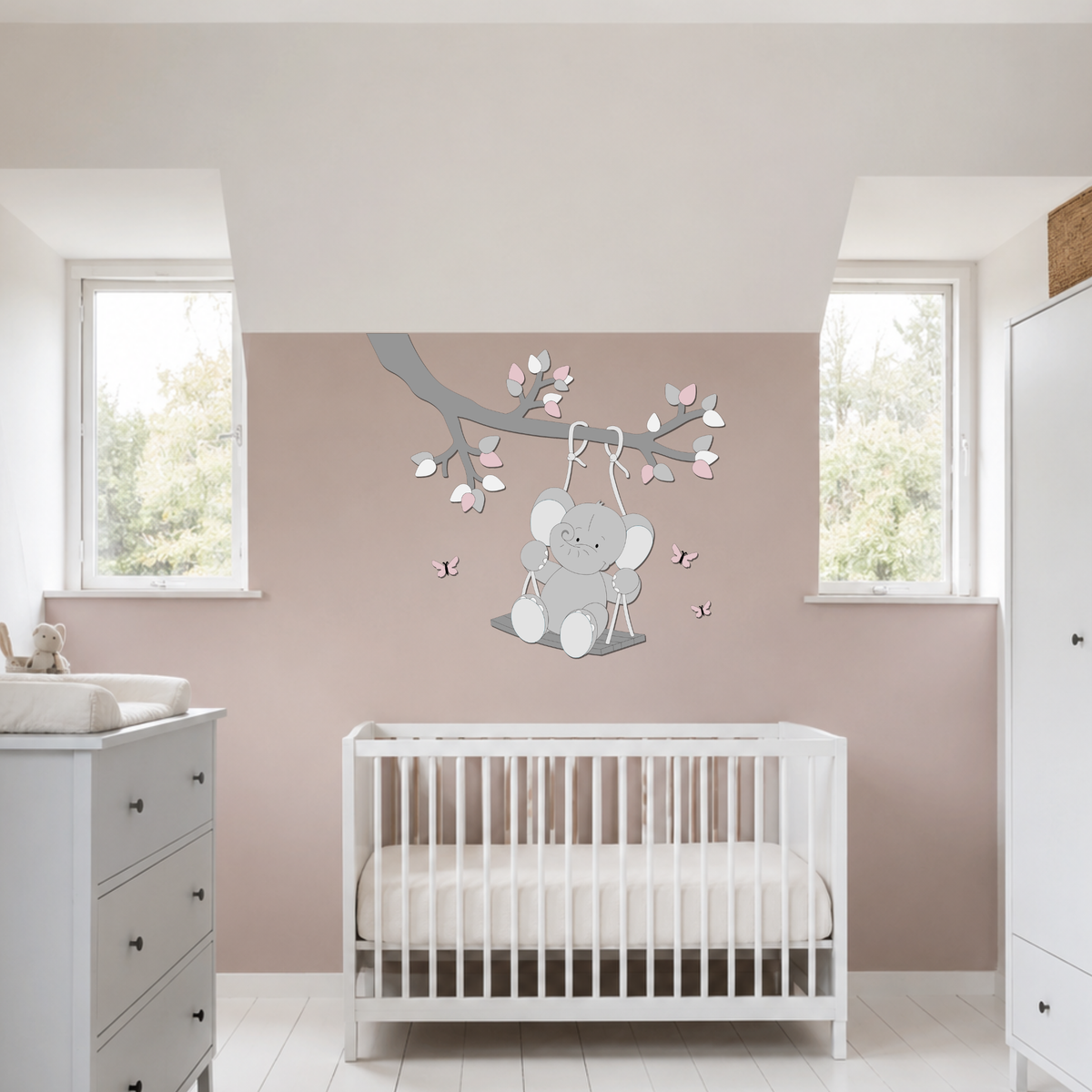 Houten muurdecoratie voor de baby- of kinderkamer met een olifantje op een schommel aan een tak, uitgevoerd in grijstinten met roze accenten, blaadjes en vlinders.