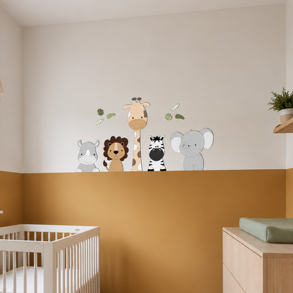 Babykamer met wit ledikant, houten commode, okergele lambrisering en muurdecoratie van jungle dieren met een nijlpaard, leeuw, giraf, zebra en olifant.