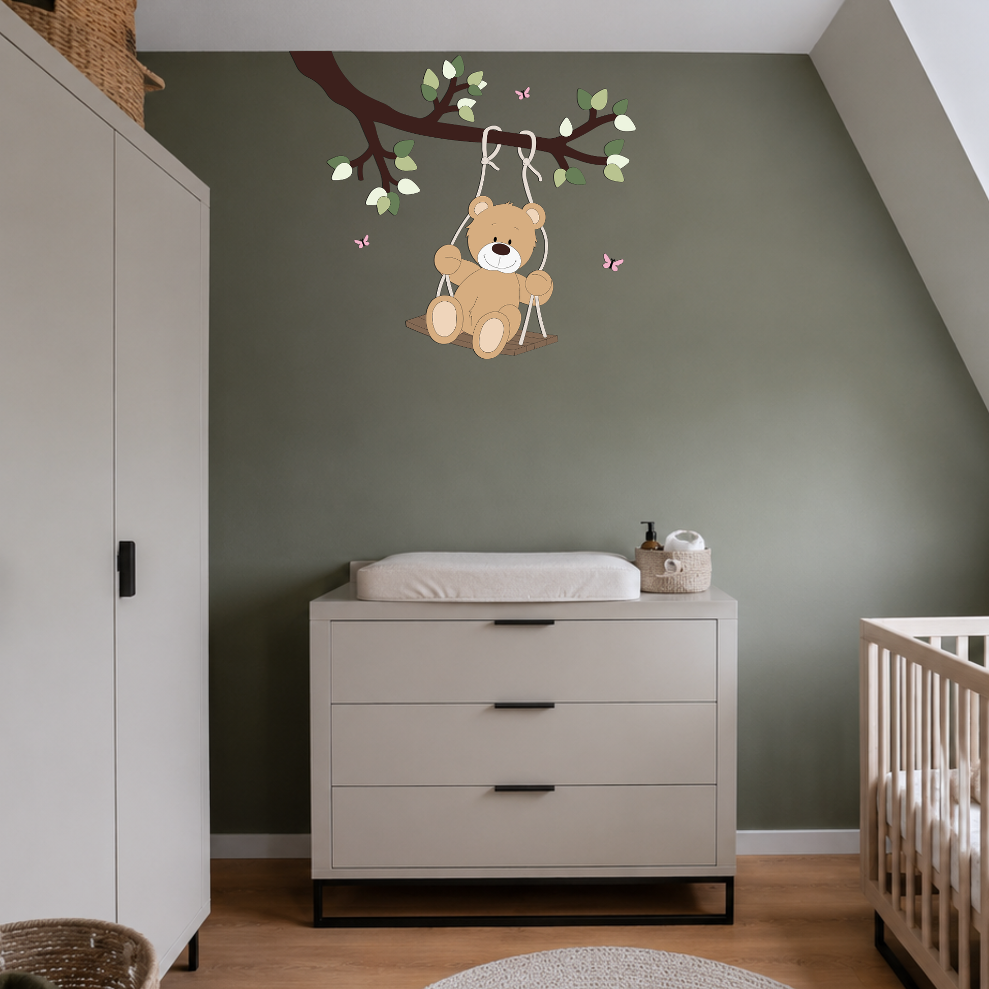 Babykamer met groene muur en lichte meubels. Wanddecoratie van tak met schommelend beertje.